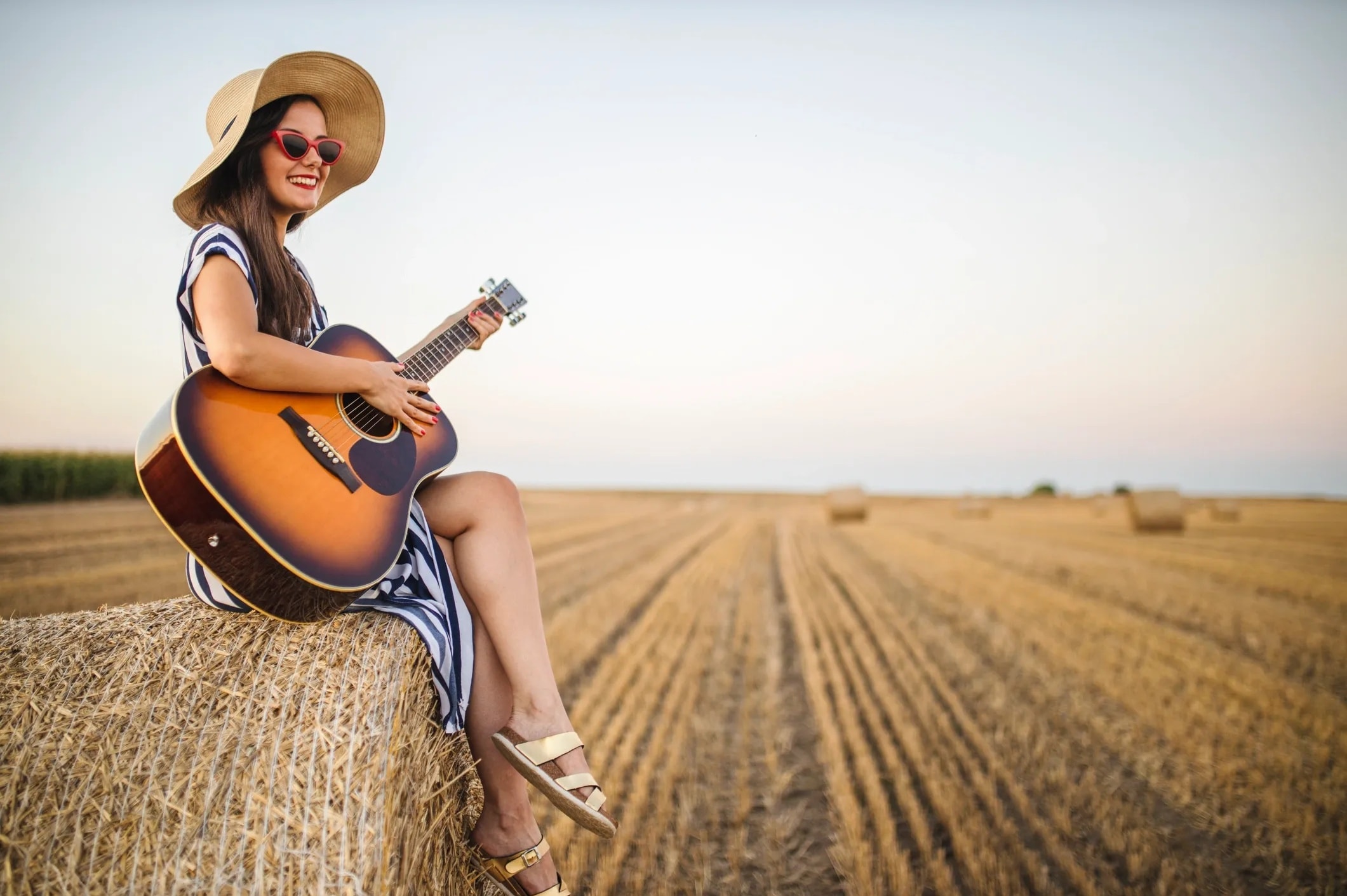 An independent musician with a guitar in an urban setting — an emerging creator waiting to be discovered on MAOZ